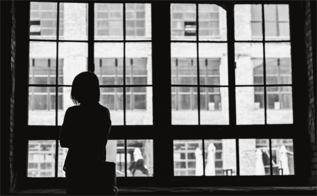 Silhoutte of person standing in front of window looking out onto street - social amxiety disorder - Bolton CBT, Emma Yarwood